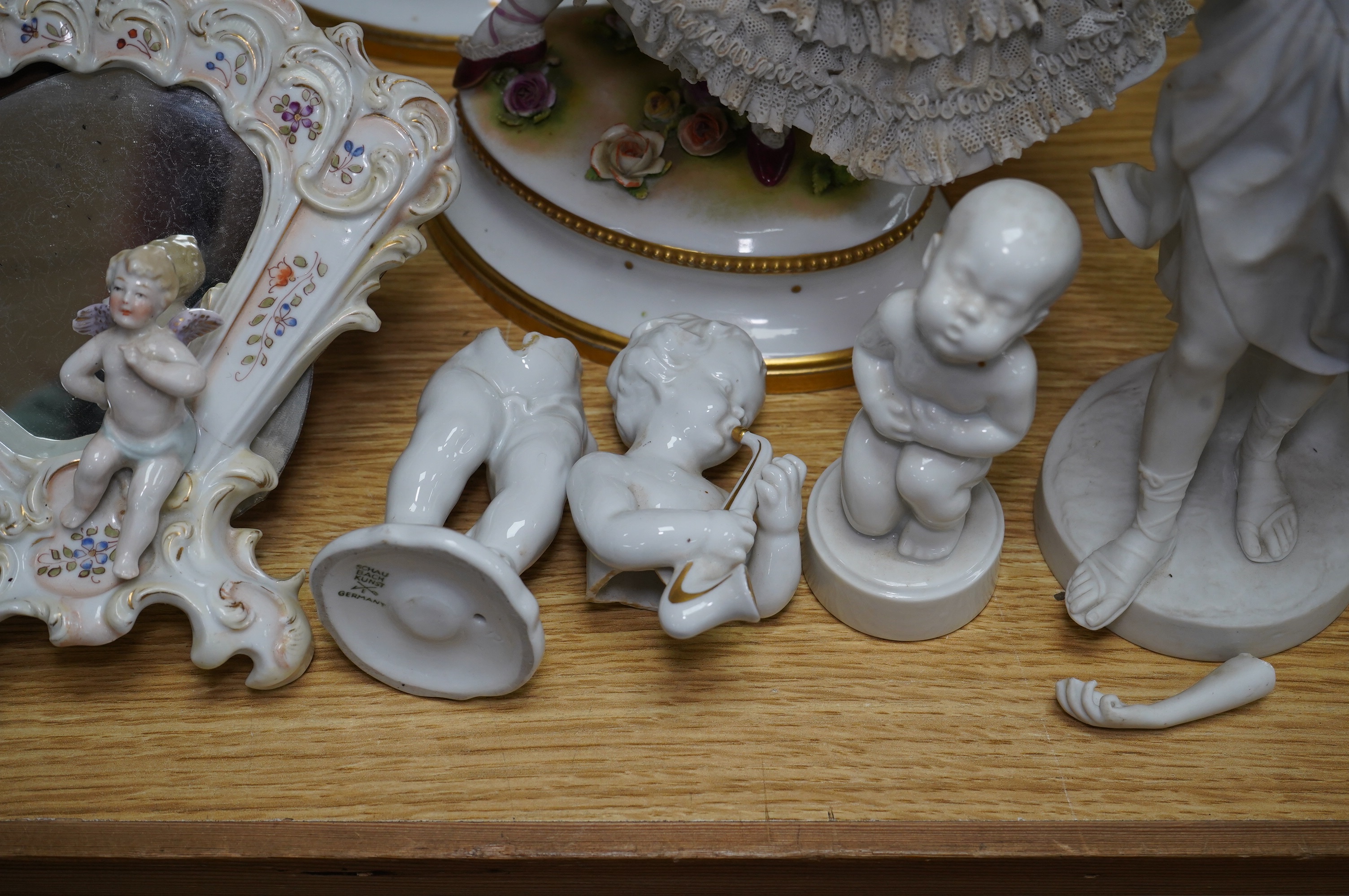 A collection of Continental porcelain ceramic figurines, including a pair of lace examples, dancing ladies and an easel mirror, largest 29cm high. Condition - mostly poor